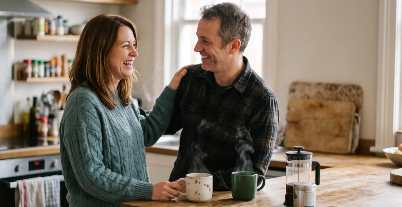 Couple souriant partageant un moment de complicité authentique à la lumière du matin, symbole d'une relation vivante après plusieurs années