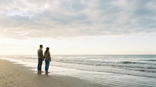 Silhouette d'un couple sur une plage au crépuscule, illustrant les marées comme métaphore des fluctuations naturelles du désir